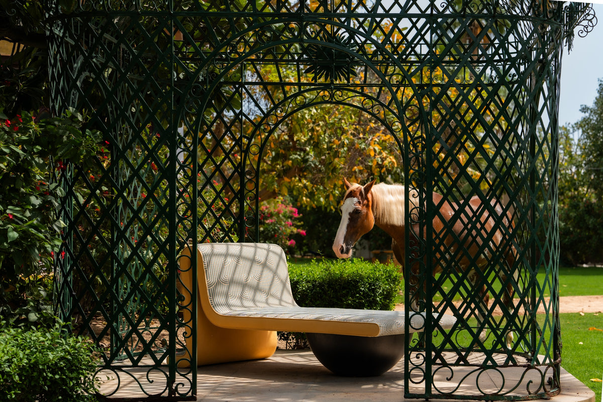Lacuna daybed in green, styled in a garden gazebo